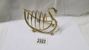 A novelty gilded metal swan toast rack, length 13 cm, height 11 cm.