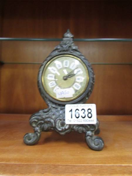 A small metal mantel clock.
