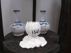A pair of white glass vases decorated with birds and a lily flower bud vase.