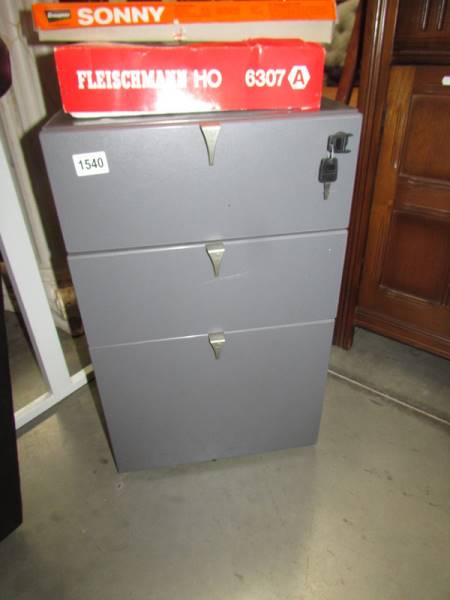 A metal lockable office cabinet on castors and with key. COLLECT ONLY.