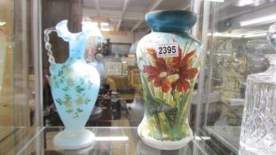 A 19th century hand painted glass vase and a blue glass jug.