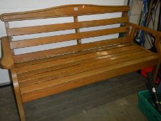 A wooden garden bench, 158cm wide (needs 3 nuts to back and varnishing.) COLLECT ONLY.