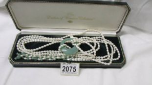 A long pearl and jade necklace.