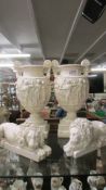 A pair of Grecian style urns and a pair of reclining lions. COLLECT ONLY.