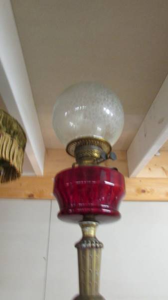 A Victorian oil lamp with ornate brass base, ruby glass font and acid etched shade. COLLECT ONLY. - Image 3 of 3