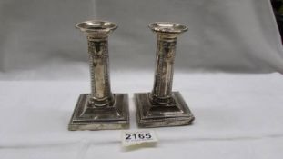 A pair of hall marked silver Regency style candlesticks, 12cm. (small dint to one base corner).