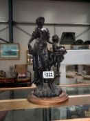 A classical style faux bronze resin figure of a woman with child