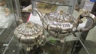 An ornate silver plate teapot and sugar bowl.