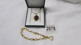 A yellow metal pendant set amethyst coloured stone and a yellow metal bracelet.