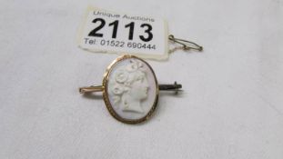 A 9ct gold cameo brooch with safety chain.