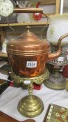 A copper kettle and a brass trivet.