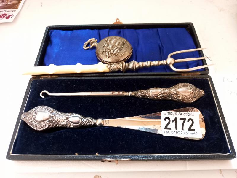 A cased silver handled shoe horn and button hook, a pickle fork and a modern pocket watch.