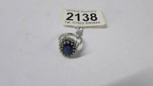 A platinum sapphire and diamond cluster ring. Size K