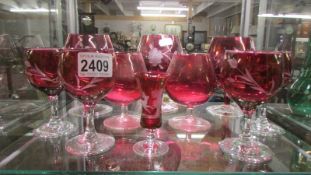Ten cranberry glass wine and brandy goblets.
