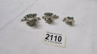 A set of three silver graduated frogs.