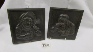 Two metal portrait wall plaques.