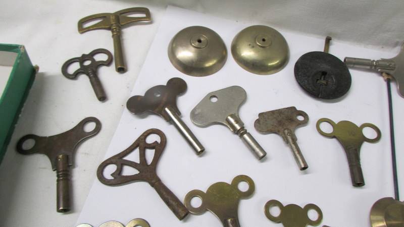 In excess of 28 old clock keys, pendulums and bells. - Image 2 of 4