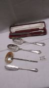 A silver handled bread knife, a silver fish knife, 2 berry spoons & spoon with mother of pearl bowl.