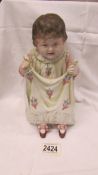 A bisque porcelain figure of a toddler.
