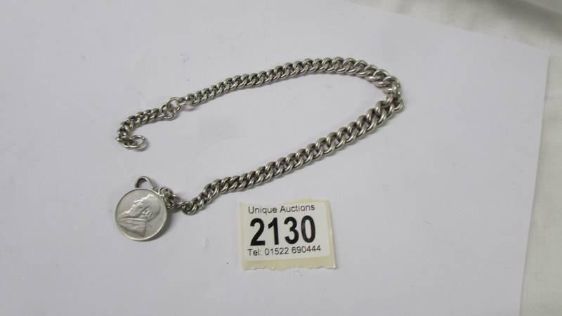 A heavy old kerb link chain with a one shilling coin, dated 1895.