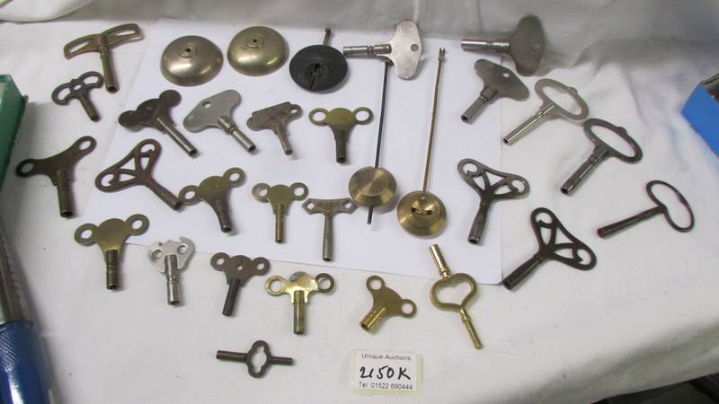 In excess of 28 old clock keys, pendulums and bells.