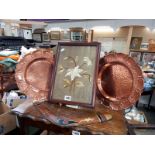 A pair of hammered copper plates, an original boomerang & a period embroidered flower picture