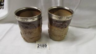 Two 19th century stoneware beakers with silver rims.