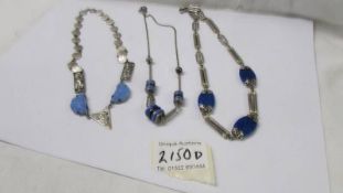 Three white metal and blue stone necklaces.