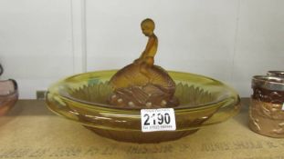 A large early 20th century amber glass rose bowl with boy sitting on a fish centre.