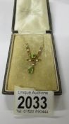 A 15ct gold pendant set peridot and seed pearls on 585 chain.