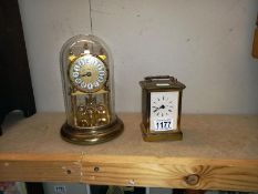 A brass Quartz carriage clock & anniversary clock under glass dome