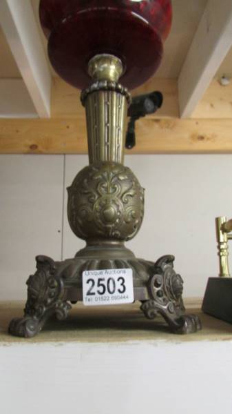 A Victorian oil lamp with ornate brass base, ruby glass font and acid etched shade. COLLECT ONLY. - Image 2 of 3