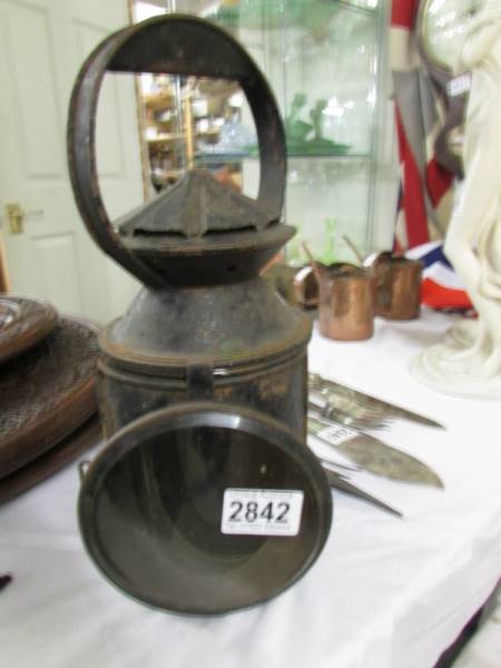 An old railway lamp with red and blue glass but clear glass missing.