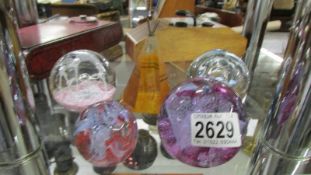 Five assorted glass paperweights.