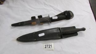 Two old knives in sheaths.