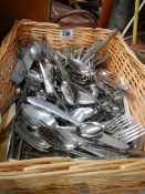 A large lot of assorted cutlery in wicker basket.