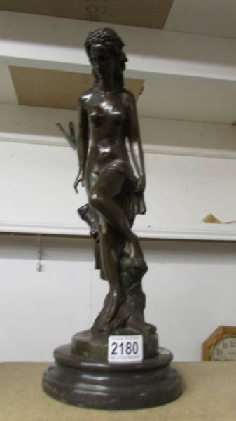 A bronze nude figure on a plinth.