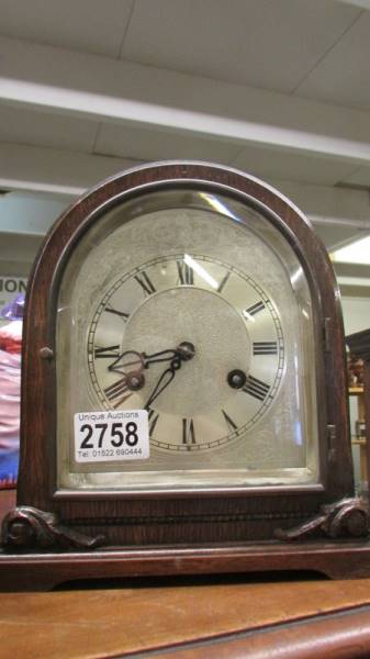 An oak 8 day mantel clock with silvered dial, in working order.