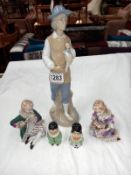 A Lladro style figure, a pair of porcelain figures & a novelty salt & pepper