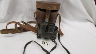 A small pair of vintage binoculars in a leather case.