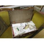 A large vintage suitcase of vintage linens, knitting, sewing, needlecraft patterns, handkerchiefs,