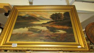 A gilt framed oil on canvas lake and mountain scene, signed but indistinct.