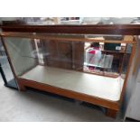 A glass display chest, wood frame and base (52cm x 59cm x 92cm height)