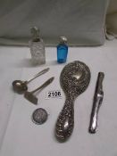 A silver spoon with pusher, a silver backed hand mirror, 2 silver topped scent bottles, a