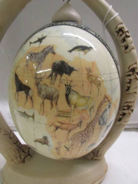 A decorated ostrich egg depicting elephants and other wild animals. - Image 3 of 6