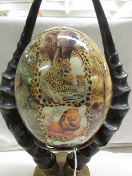 A decorated ostrich egg depicting elephants and other wild animals. - Image 3 of 5