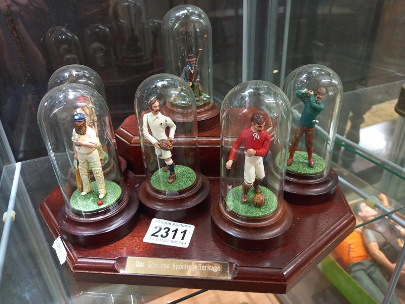 A set of 6 'Our Sporting Heritage' figures under domes and on a stand.