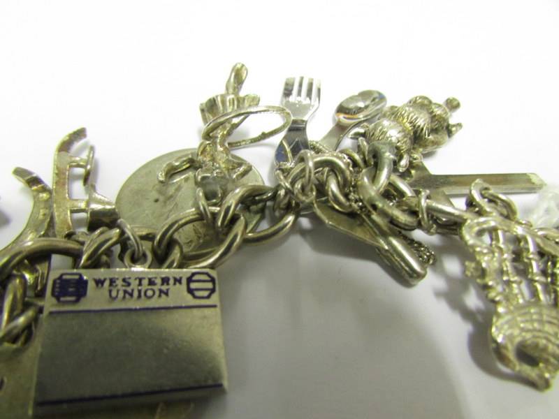 A silver charm bracelet with approximately 30 charms (5 marked 925 the rest not marked). - Image 3 of 3