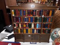 A small book case containing sets of miniature books