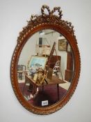 An oval mirror in Adam style plastic frame.